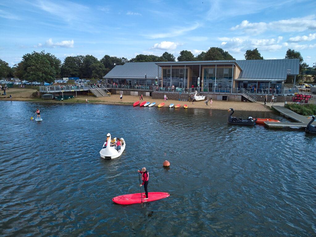 Several canoes and swan pedalos on the lake at Nene Park