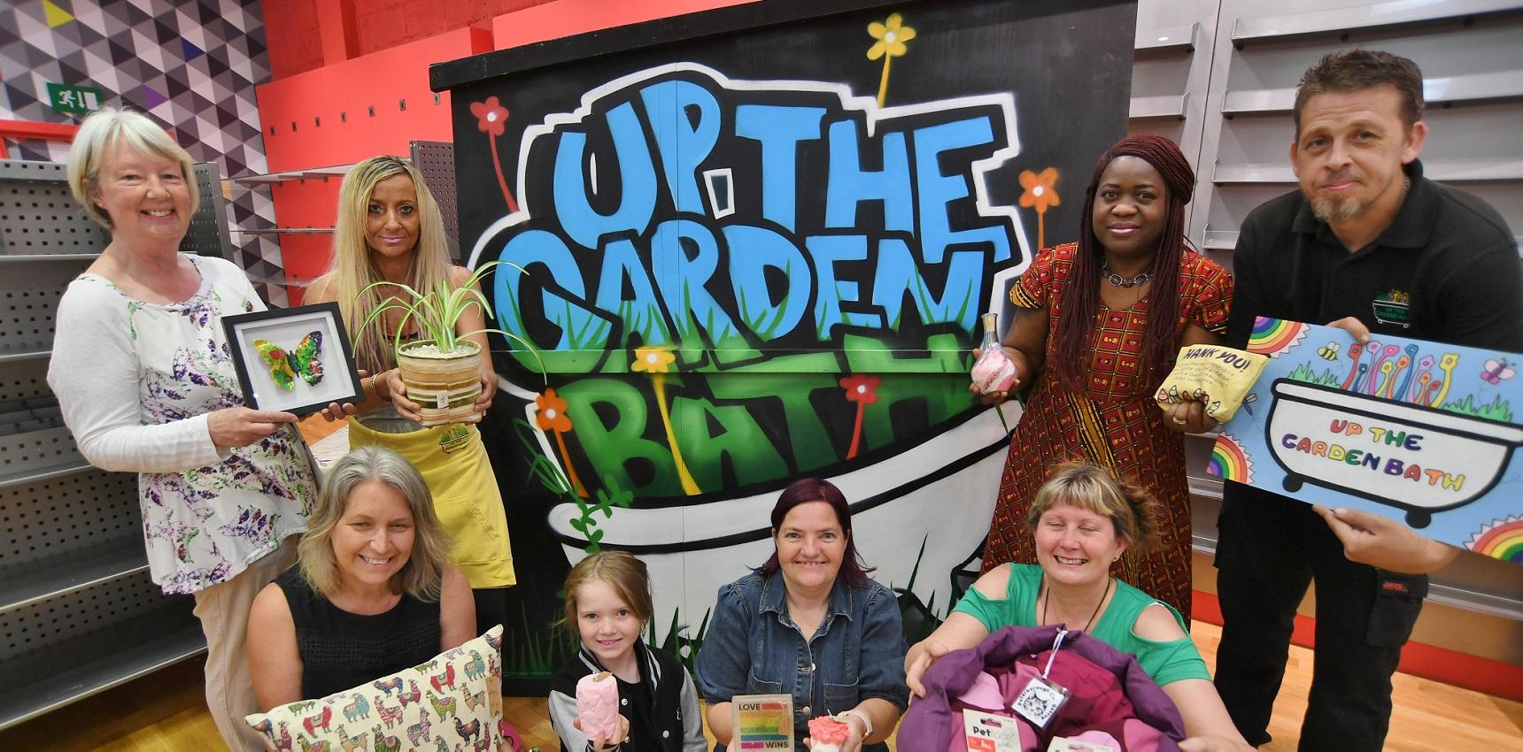 Signage for Up The Garden Path with vendors kneeling in front