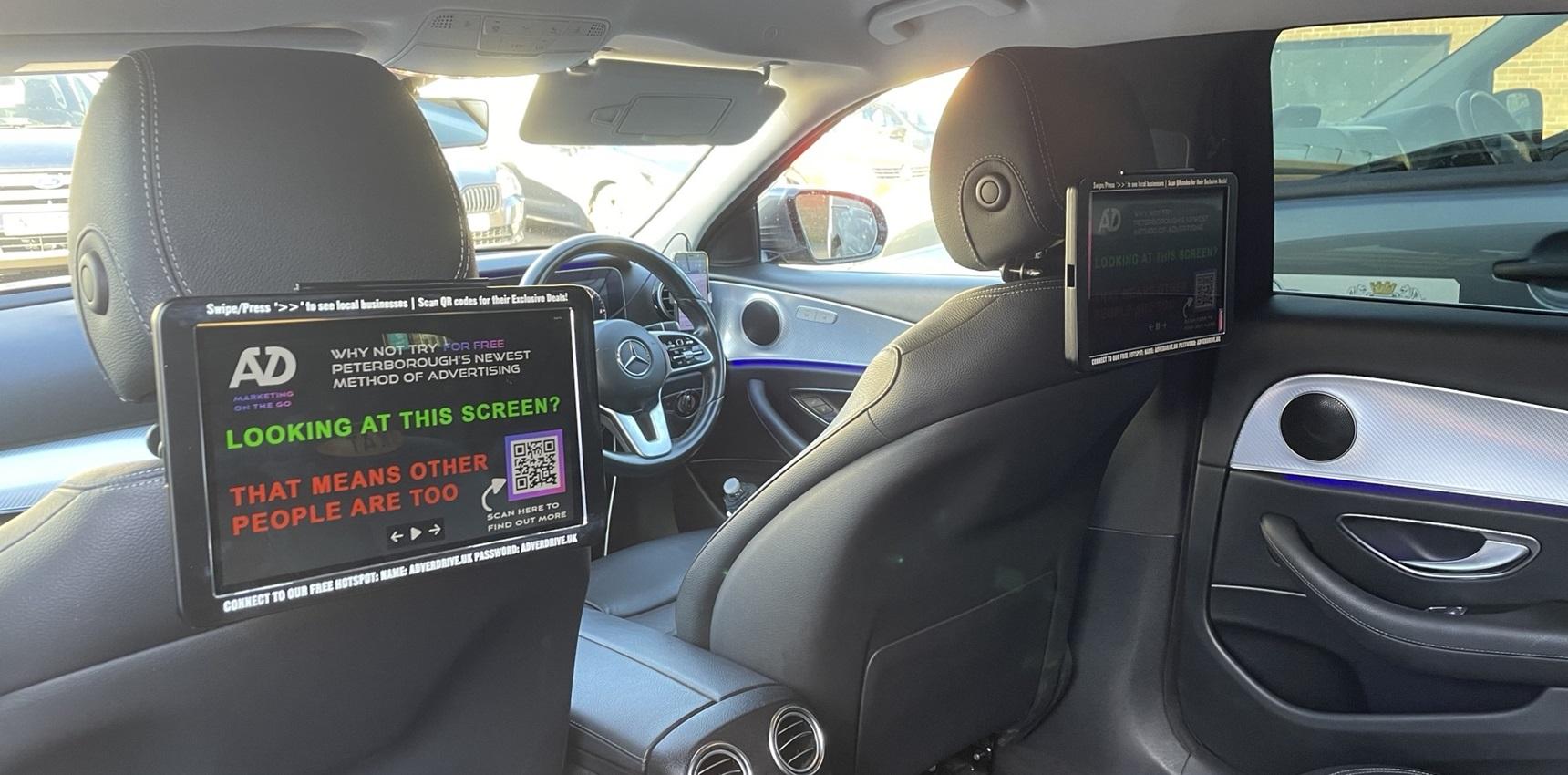 View from the back seat of a taxi-cab, showing the Adverdrive screens.