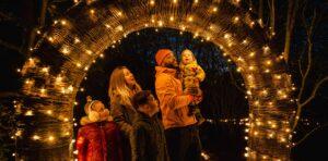 A family gathers under an arch of lights