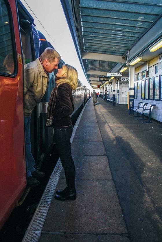 Couple saying goodbye as man get on to a train