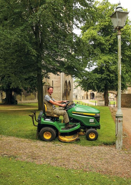 Man on Sit-and-ride mower in cathedral grounds